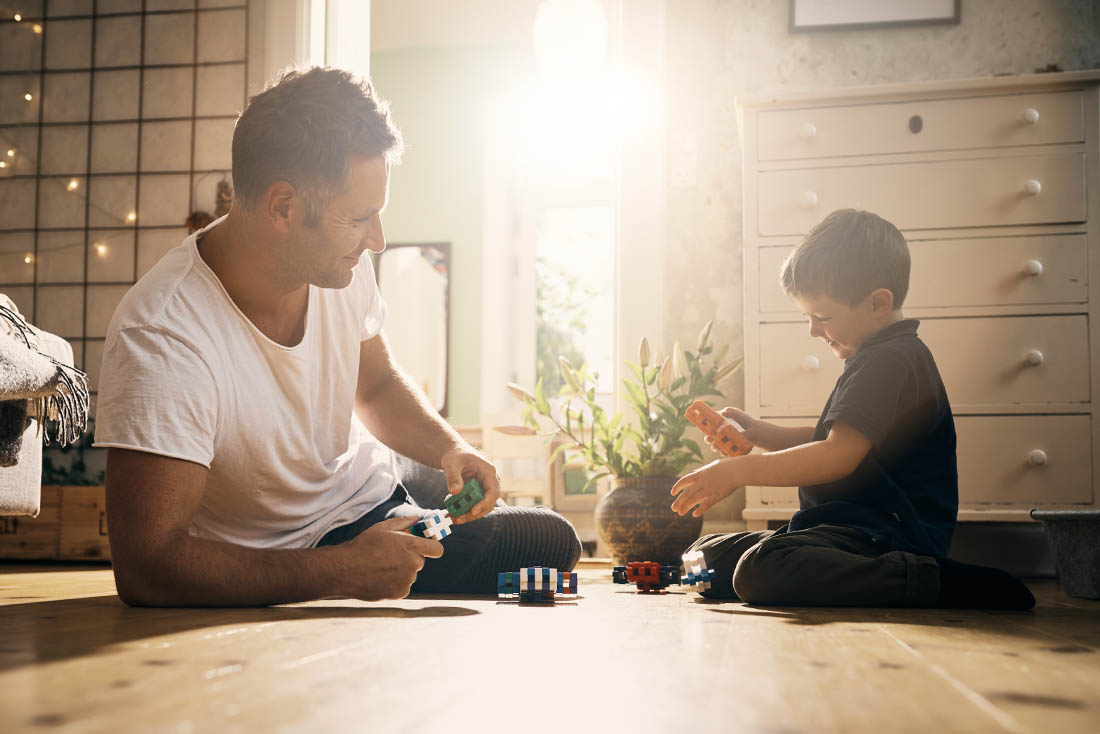 father and son playing with toys